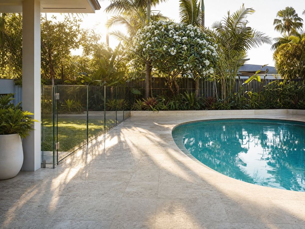 Travertine pool surround and paving, cleaned, under dappled palm shadows